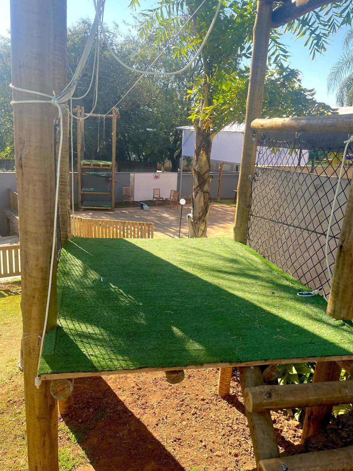 Trampolim em rede com casinha temática ao fundo em brinquedão da HM Entretenimento